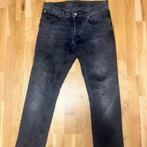 Nudie Jeans Grim Tim - Säljer ett par svarta jeans från Nudie Jeans i modellen Grim Tim. Jeansen är sparsamt använda och i väldigt fint skick. 