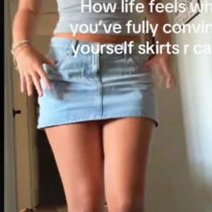 Ljusblå jeanskjol med fickor - Snygg ljusblå jeanskjol i kort modell med klassiska fickor fram och bälteshällor. Perfekt för dig som gillar en enkel och fräsch stil. Kjolen har en rak passform och stängs med knapp och dragkedja framtill.