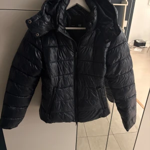 Mörkblå glansig pufferjacka från 157  - Jättepopulär mörkblå dunjacka från 157 i storlek S. Jackan har en dragkedja framtill och två fickor med dragkedja. Använd men väldigt bra skick💗pris går att diskutera(kolla gärna min profil för en liknande jacka som är svart och från Gina)