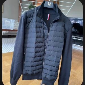 Svart Moncler Cardigan stl S/M - Säljer en riktigt fin cardigan jacka från Moncler med quiltad front och ärmar i mjuk bomull. Jackan har dragkedja, ribbade muddar och diskret Moncler-logga på ärmen. Taggar och övriga lappar är kvar. Inte ett spår av användning, haft den två kvällar. Hör av dig med frågor! Priset är redan mycket nedsatt så kom gärna inte med skambud.