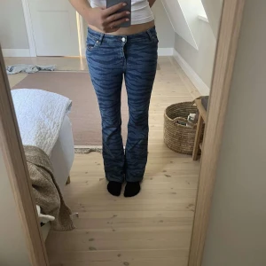Blå jeans Monki - Säljer ett par blå jeans från Monki med zebramönster. Byxorna har bootcut-modell och normal passform, klassisk femficksdesign och är tillverkade i jeansmaterial. 