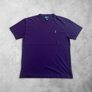 Lila t-shirt från Polo Ralph Lauren - Snygg lila t-shirt från Polo Ralph Lauren med klassisk grön broderad logga, som jag tyvärr inte använder nå mer.                                             - 68 cm lång, 51 cm bred o 18 cm ärmlängd     - Köpt men använd ett fåtal gånger ba             - 9/10 skick ba ett pyttelitet hål vid ärmen        - Rök- & djurfritt hem                                               Pris går såklart att diskutera 😘                       Hör av er gärna 🤝