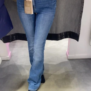 Blå bootcut jeans låg midja - Snygga blå jeans med bootcut-modell och medelhög midja. Jeansen har klassisk femficksdesign och är tillverkade i ett stretchigt denimtyg som sitter skönt. Perfekta för dig som gillar en avslappnad men trendig look.