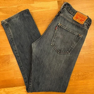 Levis jeans - Blå Levis jeans 501 storlek 32/32 (midja 41cm, längd 104cm). Köpta i london 2024. Bara lite slitet på fållen på ena byxbenet men är annars i bra skick. Bara att höra dig om du undrar något. Pris är diskuterbart.