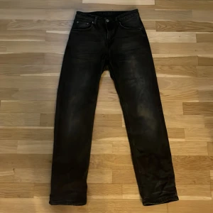 Svarta jeans från Nudie Jeans  - Säljer ett par svarta jeans från Nudie Jeans i storlek W27 L30. Äkta köpta för ca 1 år sen. Säljer den för den börja bli för små. Passar väldigt bra på en tjej/kille 55-60kg 170cm.