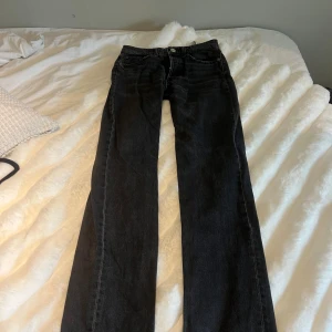 Svarta raka jeans från Zara, strl 34 - Säljer ett par svarta jeans från Zara i storlek 34. Jeansen har rak passform, med knappar där fram. Alla knappar syns inte om man knäpper de ordentligt men då de inte passar mig så kunna jag tyvärr inte knäppa alla! 