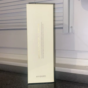 Hyggee Ph Hyaluron Gel Cleanser - Fräsch gelrengöring från Hyggee med hyaluronsyra, perfekt för att rengöra och återfukta huden. Kommer i en stilren ljusgul förpackning med guldtext. Passar dig som vill ha en mild och effektiv rengöring i din hudvårdsrutin.