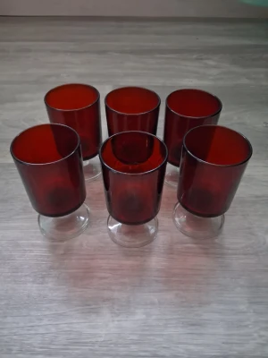 Vintage Luminarc france Sex röda glas på fot - Säljer ett set med 6st vintage Luminarc France Cavalier glas på fot i mörkrött glas samt transparent glas. Ena glaset har ett litet märke på sig men ingenting som känns. Höjd 9cm Diameter 5cm. Passar dig som gillar retro eller vill ha något unikt till köket.