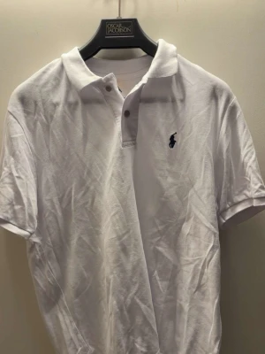 Ralph Lauren Polo Shirt – Size M – White - Classic white polo shirt from Ralph Lauren in size M. Used sparingly and kept in very good condition with no stains or damage.  Features the iconic embroidered Polo logo on the chest. Made from comfortable cotton and perfect for both casual and smart-casual outfits. A timeless wardrobe staple.  Feel free to message me if you have any questions 😊