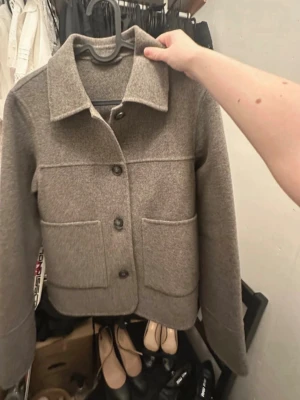 Ullkappa med krage &other stories - Hej! Säljer denna helt oanvänd ulljacka i st XS. Längden är 56cm och breden 48 cm. Köpte den för en månad sedan. Säljer den då jag glömde att skicka tillbaka den i tid. Eftersom att man inte får lägga in bilder från hemsidan kommer en länk till jackan - https://www.stories.com/sv-se/product/collared-wool-jacket-grey-1255237003/.  Nypris 1590kr