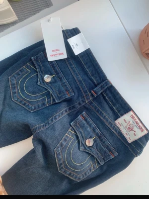 True Religion blå jeans med ficklock - Säljer ett par helt nya och oanvända true religon jeans med prislapp kvar, i storlek w26. Dom är lågmidjade och utsvängda. Köpte dom för 1299 obs pris går att diskutera 