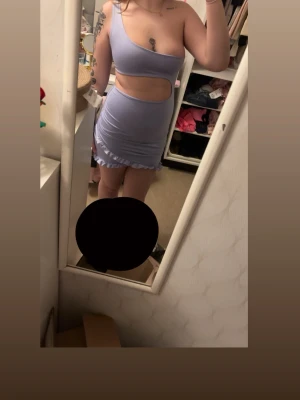 Ljuslila kort klänning med volang - Supersöt ljuslila kort klänning med cut-out i midjan och volangdetaljer längs nederkanten. Klänningen är ärmlös och har en tight passform som framhäver figuren!