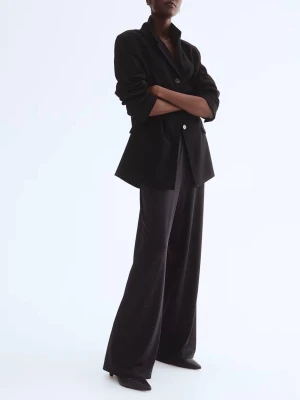 Svarta vida kostymbyxor i satin från H&M - Snygga svarta kostymbyxor med breda ben och diskret prickigt mönster. Byxorna har en hög midja och är tillverkade i glansigt satinmaterial som ger en lyxig känsla. Perfekta för dig som gillar en trendig och avslappnad look.