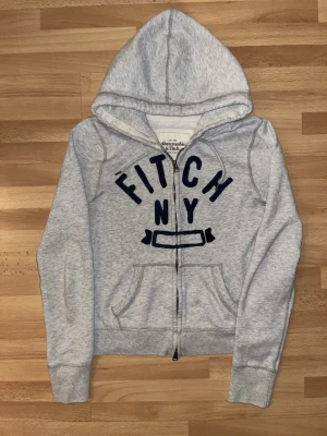 Grå Abercrombie & Fitch hoodie - Snygg grå vintage A&F hoodie, står L men sitter som XS/S. Priset inte hugget i sten. tveka inte att höra av dig vid funderingar! 