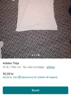 Vit Adidas t-shirt med stor logga - Säljer en vit t-shirt från Adidas i storlek 164. T-shirten har klassisk passform, korta ärmar och en stor svart Adidas-logga framtill. Tillverkad i mjuk bomull som är skön att ha på sig. Perfekt för dig som gillar sportiga och stilrena plagg.