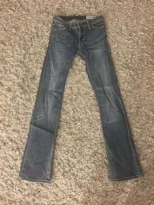 Lågmidjade bootcut crocker jeans   - Snygga blå bootcut jeans från crocker med klassisk femficksmodell och normal passform. Jeansen har en lätt tvättad look och är tillverkade i mjuk bomull med lite stretch för extra komfort.