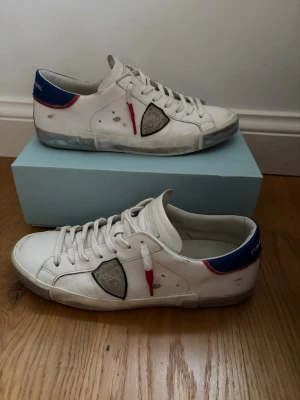Vita Philippe Model sneakers - Hej 👋 jag säljer dessa fetta Philippe model skor som är i väldigt bra skick inga defekter och har bara använts några gånger. Allt på bilderna ingår alltså skorna, dustbag, box och en etikett. Frakt inom 24‼️storlek 45‼️äkta!