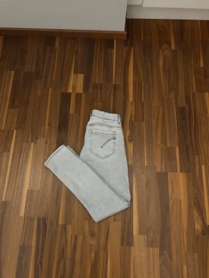 Ljusgrå raka jeans - Snygga ljusgrå jeans med raka ben och klassisk femficksdesign. Jeansen har en enkel look utan slitningar eller dekorationer, perfekta för en clean och stilren outfit. Tillverkade i mjukt denimtyg som ger en bekväm känsla hela dagen.