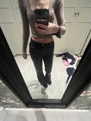 Svarta lågmidjade raka skinnbyxor - Säljer ett par svarta skinnbyxor med låg midja och raka ben. Skinnbyxor  har klassisk femficksmodell och knappgylf. Materialet är skinnbyxor i bomull med lite stretch för extra komfort. Perfekta till en enkel topp eller hoodie.