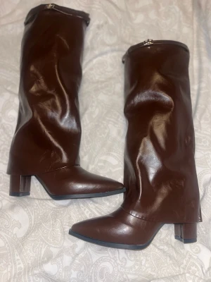 Bruna höga stövlar i skinn - Snygga bruna stövlar med spetsig tå och låg klack. Tillverkade i mjukt skinn med slouchy passform och dragkedja upptill. Perfekta för dig som vill ha en snygga stövlar💕💕