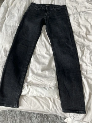 Svarta straight jeans från Levi's - Snygga svarta jeans från Levi's i klassisk straight modell. Jeansen har fem fickor, bälteshällor och diskreta slitningar för en cool look. Perfekta till vardags och passar till det mesta. Tillverkade i mjukt och slitstarkt bomullsmaterial.