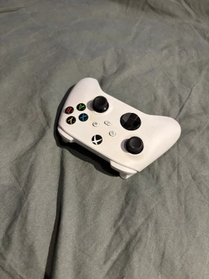 Vit Xbox-handkontroll - Snygg vit Xbox-handkontroll med klassisk design, svarta styrspakar och färgade knappar. Perfekt för gaming på Xbox eller PC. Ergonomisk form och tillverkad i tålig plast. Billigare vid snabb affär 