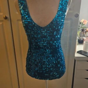 Topp - Köpt av en annan säljare på vinted för 500 kr. Säljaren sa ej att vissa paljetterna hade tappat lite färg, syns dock ej på långt håll. Därför säljer jag den vidare för billigare pris, passar S/M!