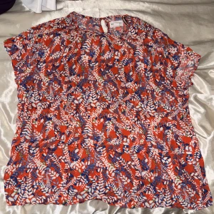 blus från holy white - Snygg mönstrad sommarblus, med volanger i ärmarna och fina guld detaljer 