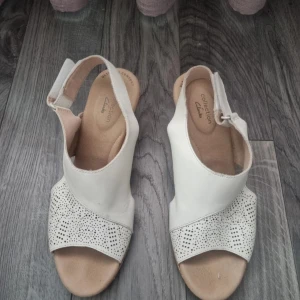 Vita kilklackade sandaler från Clarks - Bara använt ett par gånger. - Ovandelen är av slätt läder och fodret av textil. - Klack/yttersula: Gummi