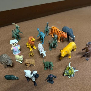 Blandade djur- och dinosauriefigurer - plastfigurer: dinosaurier, lejon, tiger, elefant, får, björn, hund, apa, och fler. Färgglada och varierade, vissa med mindre slitage men i gott skick. Perfekt för lek eller samling. 10 kr st