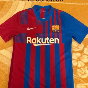 FC Barcelona matchtröja Nike S - Säljer en officiell FC Barcelona matchtröja från Nike i storlek S. Tröjan har klassiska blå och röda vertikala ränder, klubbmärke på bröstet och Rakuten-tryck framtill. Tillverkad i lätt och ventilerande material, perfekt för fotboll eller att bära som supporter.