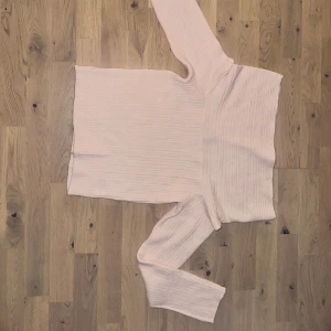 Divided rosa tröja, storlek XS Ljusrosa ribbad stickad tröja Divided - Superfin ljusrosa stickad tröja från Divided med ribbat mönster. Tröjan har lång ärm och en bred, nedvikt krage som ger en snygg offshoulder-look. Perfekt för dig som gillar en enkel men trendig stil.Ljusrosa tröja med lång ärm och hög krage. 