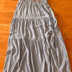 Söt ljusblå kjol - En söt och blommig ljusblå kjol i storlek S. Resor i midjan. Lite använd, därför i mycket bra kvalitet.