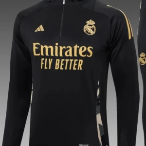 Real Madrid långärmad träningströja Adidas - Snygg svart långärmad Real Madrid träningströja från Adidas med guldfärgade detaljer och klubbmärke. Tröjan har halv dragkedja framtill och är tillverkad i ett lätt, sportigt material. Perfekt för dig som vill ha en stilren look på planen. Dragkedjan fungerar inte som den ska