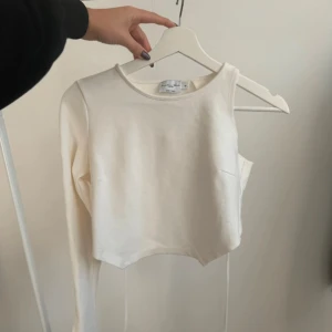 Festlig croptop med öppen rygg - Vit croppad topp med öppen rygg från NAKD (Angelica Blick x NAKD) i storlek M. Snörning bak. Använd 1-2 gånger och är därmed i mycket bra skick.