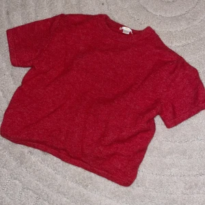 Röd stickad kortärmad tröja Gina Tricot - Röd stickad tröja från Gina Tricot i storlek 158/164. Tröjan har korta ärmar, rund halsringning och en enkel, clean look. Perfekt för dig som vill ha en basic men ändå mysig vibe till din outfit.