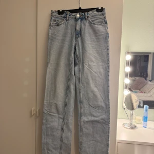 Ljusblå low straight jeans från Gina - Ljusblå jeans från Gina i klassisk femficksmodell. Jeansen har raka ben, normal passform och medel midja. Tillverkade i denim med snyggt tvättad look och detaljer som nitar och knappstängning. Perfekta för en chill och stilren vardagsoutfit.