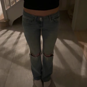 Jeans från Nelly  - Jeans från Nelly, knappar på fickorna där bak och hål i knäna fram 