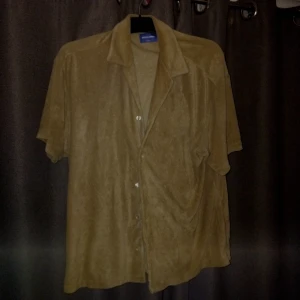 Beige kortärmad skjorta Jack & Jones - Snygg beige skjorta från Jack & Jones med korta ärmar och klassisk krage. Skjortan har knappar framtill och är gjord i mjuk manchester som ger en stilig och cool look. Perfekt för dig som gillar avslappnad stil med en stilig touch.