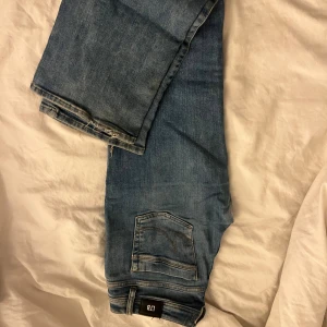 Blå bootcut jeans från LTB W29 L30 - Säljer ett par blå bootcut jeans från LTB i modellen valerie. Jeansen har klassisk femficksdesign, snygga slitningar och är tillverkade i bomull med en skön passform. Perfekta för dig som gillar en avslappnad och trendig look.
