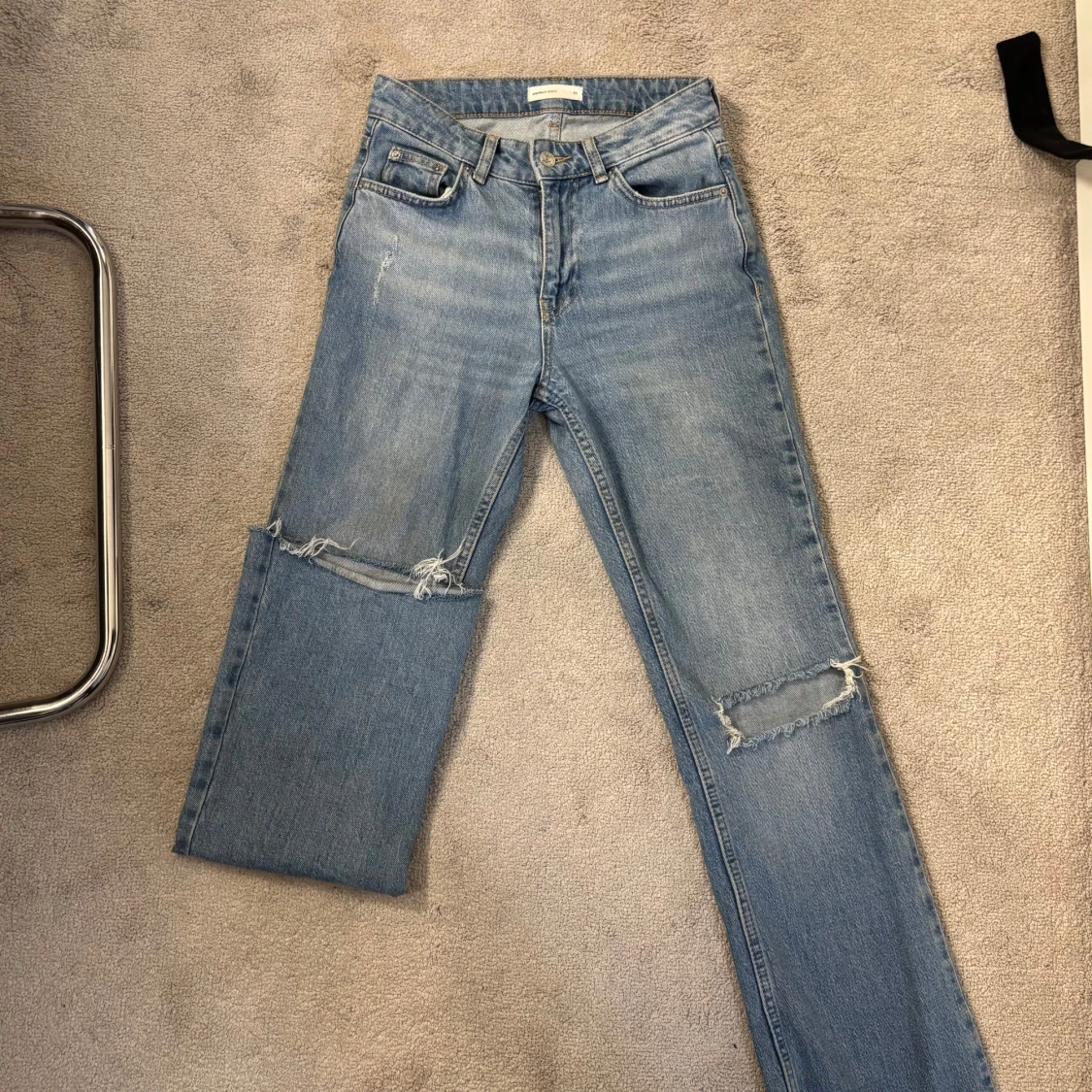 Ljusblå slitna jeans med hål