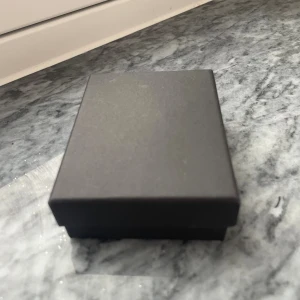 5 Svarta smyckesaskar i enkel design - En stilren svart smyckesask med klassisk rektangulär form. Perfekt för att förvara eller ge bort smycken som örhängen, ringar eller halsband. Asken har en mjuk insida för att skydda dina favoritsmycken.