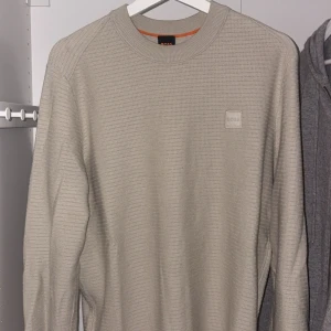 Beige långärmad tröja från BOSS - Använd fåtal gånger, köpt från NK i Göteborg .