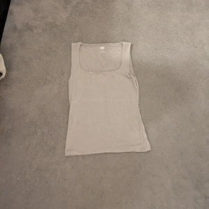 Beige linnetopp från 157 - Säljer en enkel och stilren beige linnetopp från Lager 157. Toppen har en fyrkantig halsringning och är ärmlös.