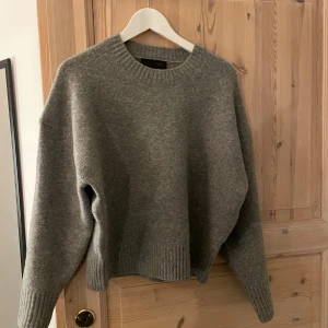 Grå stickad tröja från Zara - Säljer en grå stickad tröja från Zara i storlek XS. Tröjan har en rund halsringning, ribbade muddar vid ärmslut och nederkant samt långärmad passform. Perfekt för dig som gillar en enkel och chill look med loose fit.