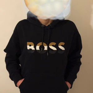 Svart Hugo Boss hoodie - Svart hoodie från Hugo boss, hoodien är i väldigt bra skick och har en väldigt skön passform. Just denna hoodie är väldigt svår att få tag i eftersom att den inte säljs eller görs längre.