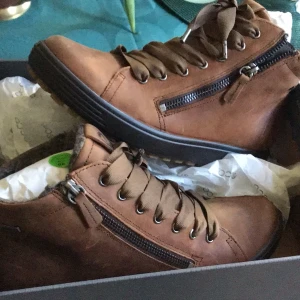 Bruna ECCO Soft 7 Tred boots strl 38 - Snygga bruna boots från ECCO i modellen Soft 7 Tred. Skorna har snörning, dragkedja på sidan och grov sula för extra grepp. Tillverkade i skinn med mjukt foder för skön komfort. Perfekta för höst och vinter när du vill ha både stil och funktion.