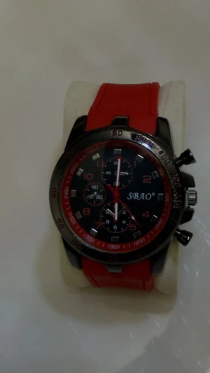 SBAO sportig röd klocka - Säljer en snygg klocka från SBAO med rött silikonarmband och svart urtavla med röda detaljer. Klockan har flera små urtavlor, markerade siffror och metallfärgad boett. Perfekt för dig som gillar sportig och modern stil.