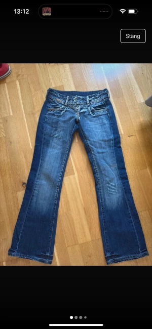 Lågmidjade bootcut jeans - Snygga Lågmidjade jeans med en sliten stil! Dom är knappt använda och har inga skador❤️W25 och midjemåttet är runt 35cm rakt över, innerbenslängden är runt 78cm! 