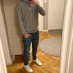 Dondup George  - Säljer ett par snygga dondup jeans i blå tvätt med coola slitningar och lätt blekta detaljer. Klassisk femficksmodell med orange sömmar och logga på bakfickan. Passformen är rak och normal, perfekt för dig som gillar en avslappnad stil. Är lite osäker på storleken på byxorna men skulle gissa att dem är runt 30-31W och 30L. Han på bilden är 185 å väger ca 70 kg. Skriv vid minsta fundering.